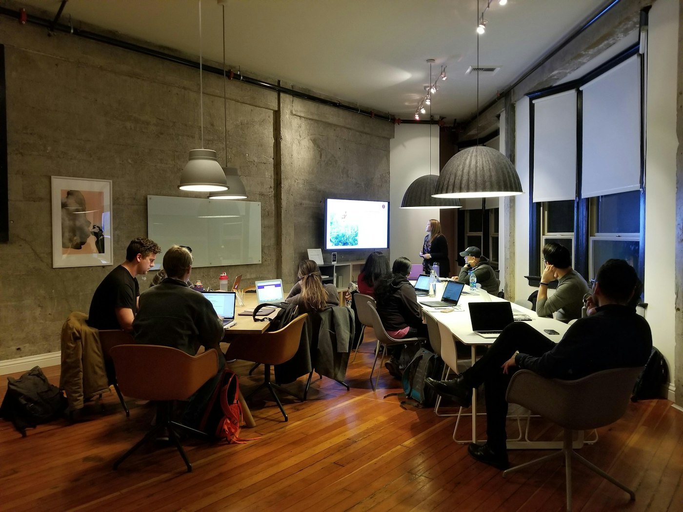 Personnes travaillant sur ordinateur dans un atelier le soir