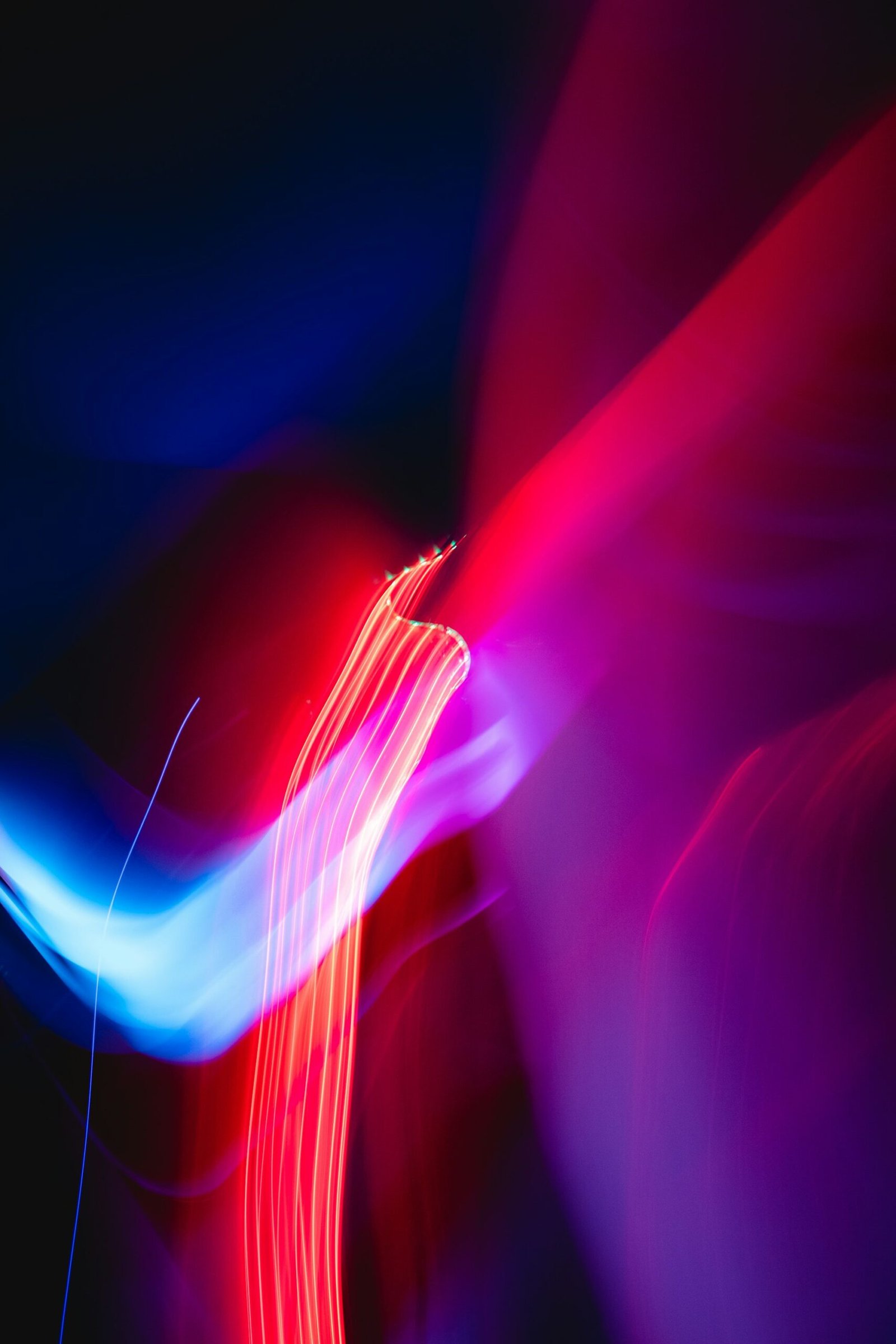 Traînées de lumière rouge et bleue sur fond noir